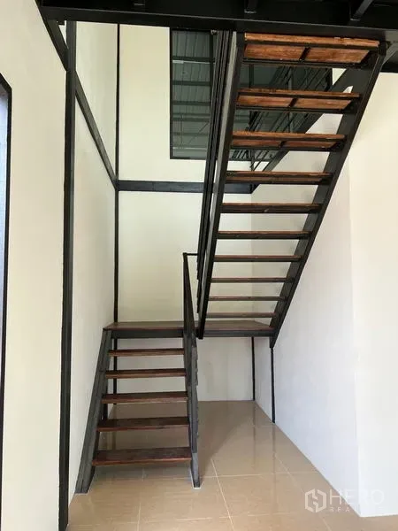 Warehouse for rent in Lam Luk Ka, Pathum Thani - Steel-and-wood staircase leading to the mezzanine office inside the warehouse.