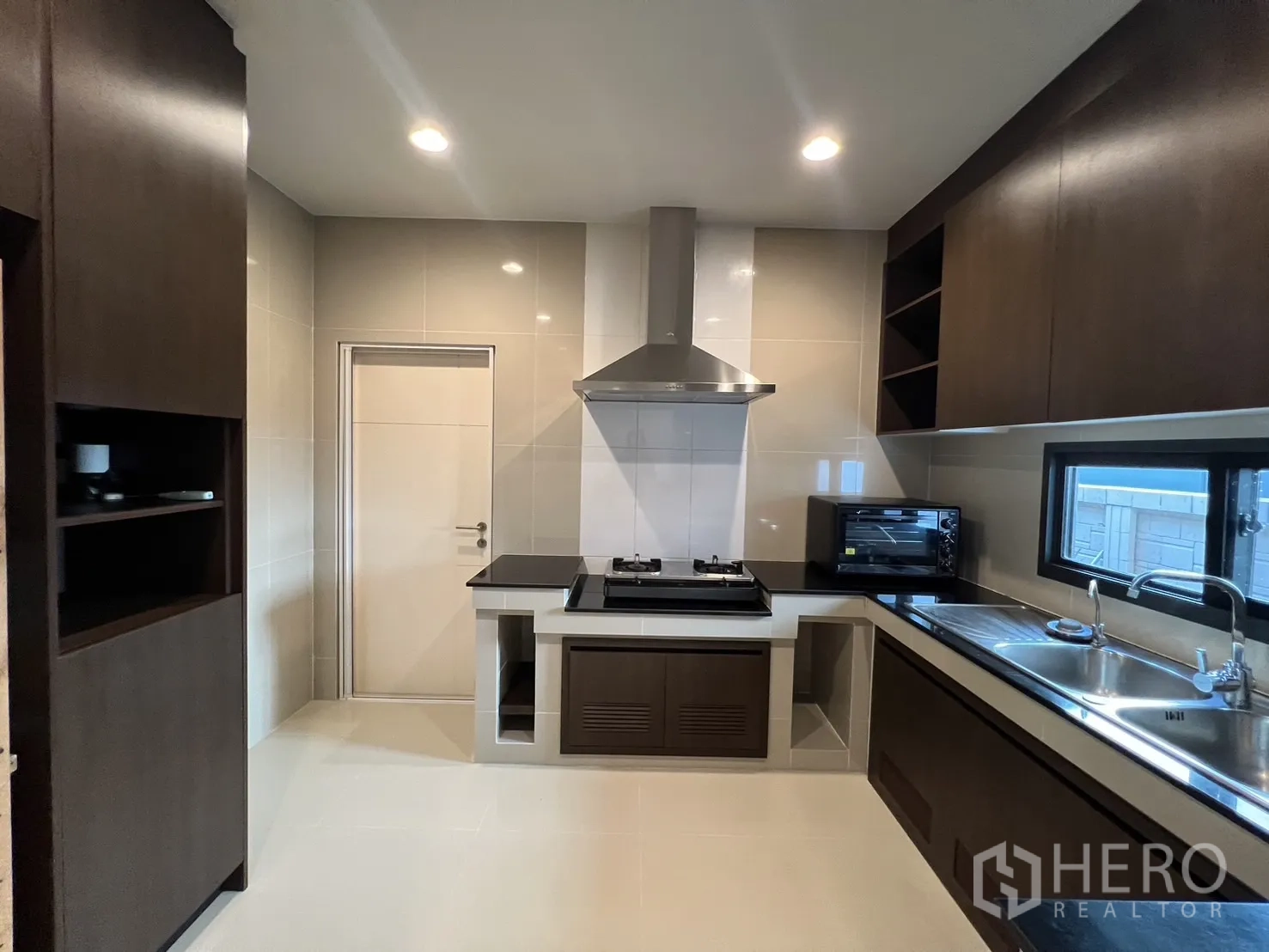 独立式住宅 出租或出售在Bang Kapi, Bangkok - 内置厨房，燃气灶、抽油烟机与深色木柜。