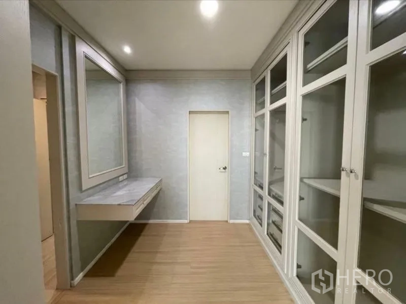 Townhouse for sale - Walk-in closet with full-height glass cabinets and a floating vanity.
