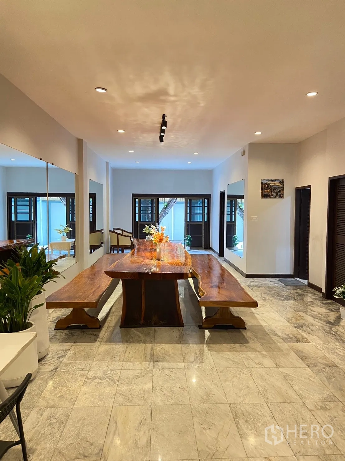 Home Office for rent in Watthana, Bangkok - Large reception hall with marble floors, long live-edge wooden table, mirrors and recessed lights.