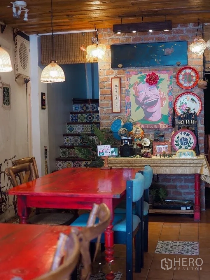 Retail Space for rent in Watthana, Bangkok - Feature wall with pop-art artwork, tiled staircase, and red dining tables in the retail space.