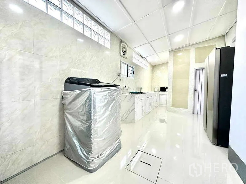 Detached House for rent in Lat Krabang, Bangkok - Spacious Thai kitchen and laundry with glossy tiles, washing machine and built-in cabinets.