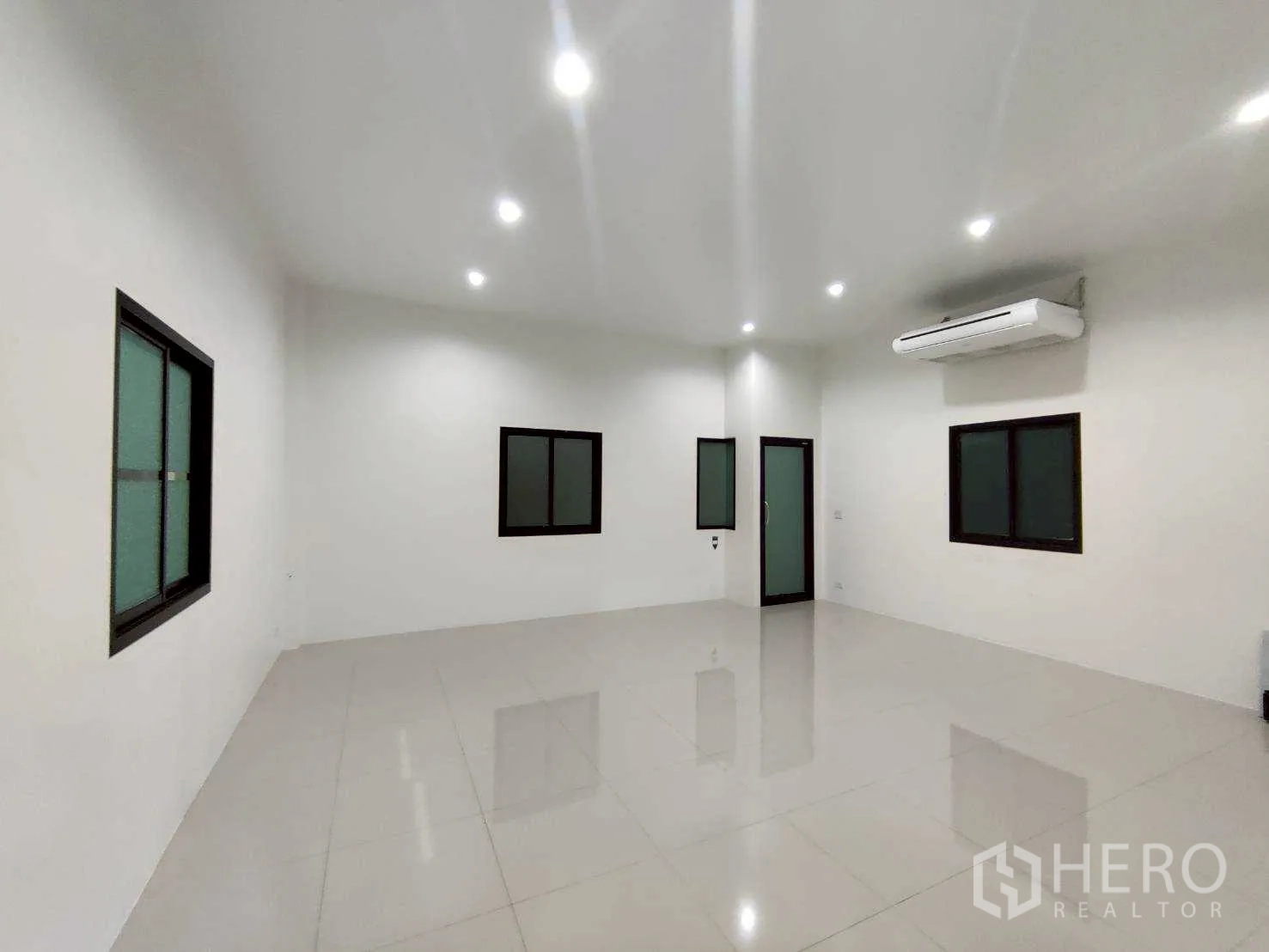 Warehouse for rent in Lam Luk Ka, Pathum Thani - Air-conditioned office room with tiled floor, recessed lighting, and black-frame windows.