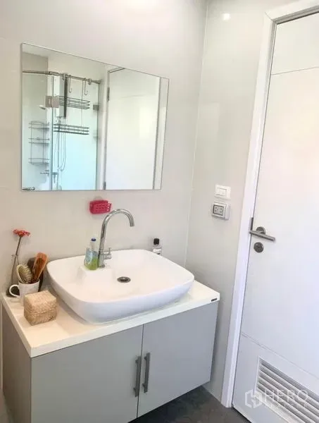 Townhouse for rent in Suan Luang, Bangkok - Bright bathroom with square countertop basin, mirror and a view of the glass shower.