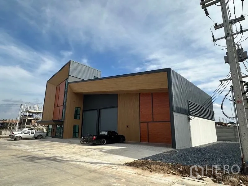 Warehouse for sale in Lam Luk Ka, Pathum Thani - Modern high-bay warehouse with attached glass-front office and wide driveway in Lam Luk Ka.