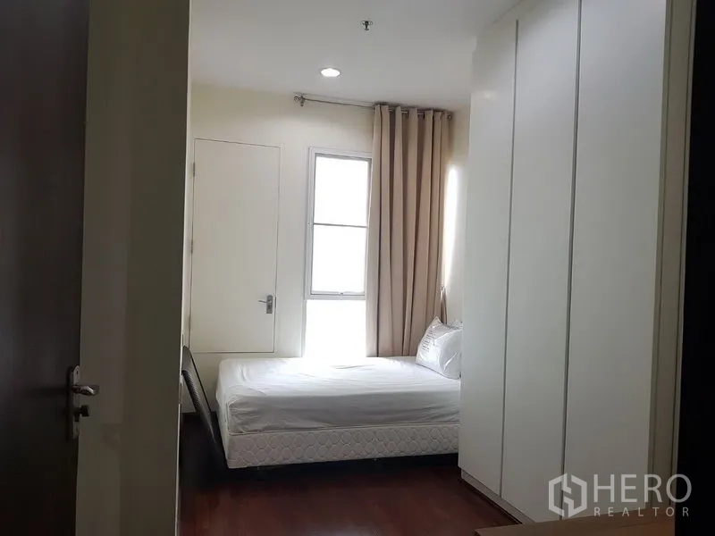 คอนโด ให้เช่าในPathum Wan, Bangkok - ห้องนอนที่สองเตียงเดี่ยว ตู้เสื้อผ้าบิวต์อิน และหน้าต่างพร้อมผ้าม่านสีเบจ