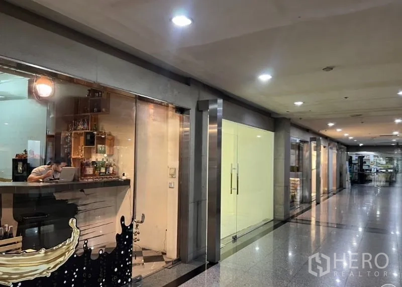 Retail Space for rent in Watthana, Bangkok - Interior mall corridor with bright glass shopfronts beside the available retail space.