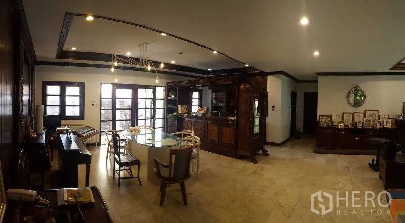 独立式住宅 出租在Bang Phli, Samut Prakan - 餐区设玻璃餐桌、复古木吧台与法式门窗。