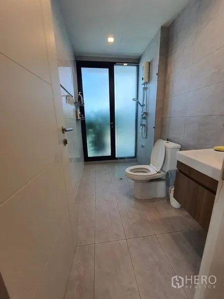 联排别墅 出售在Lat Phrao, Bangkok - 现代浴室，淋浴区、磨砂玻璃门与瓷砖墙面。