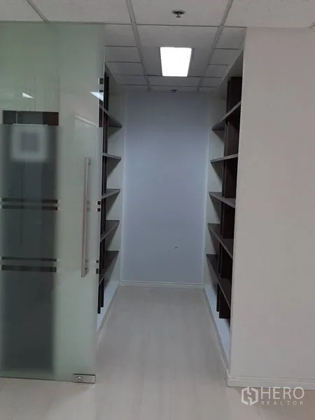 Office Space for rent in Bang Rak, Bangkok - Archive corridor with sliding glass door and twin rows of open shelving.