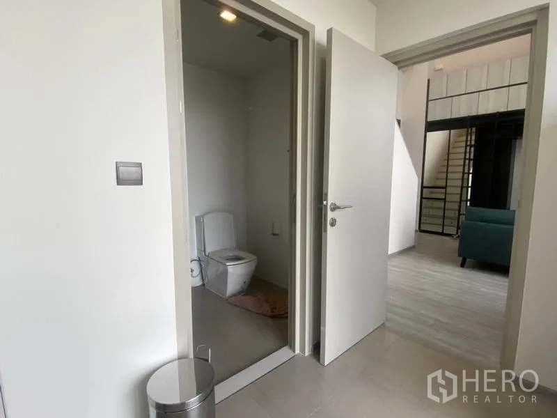 公寓 出租在Phra Khanong, Bangkok - 入口过道设独立卫生间，旁为通往客厅的敞开门。