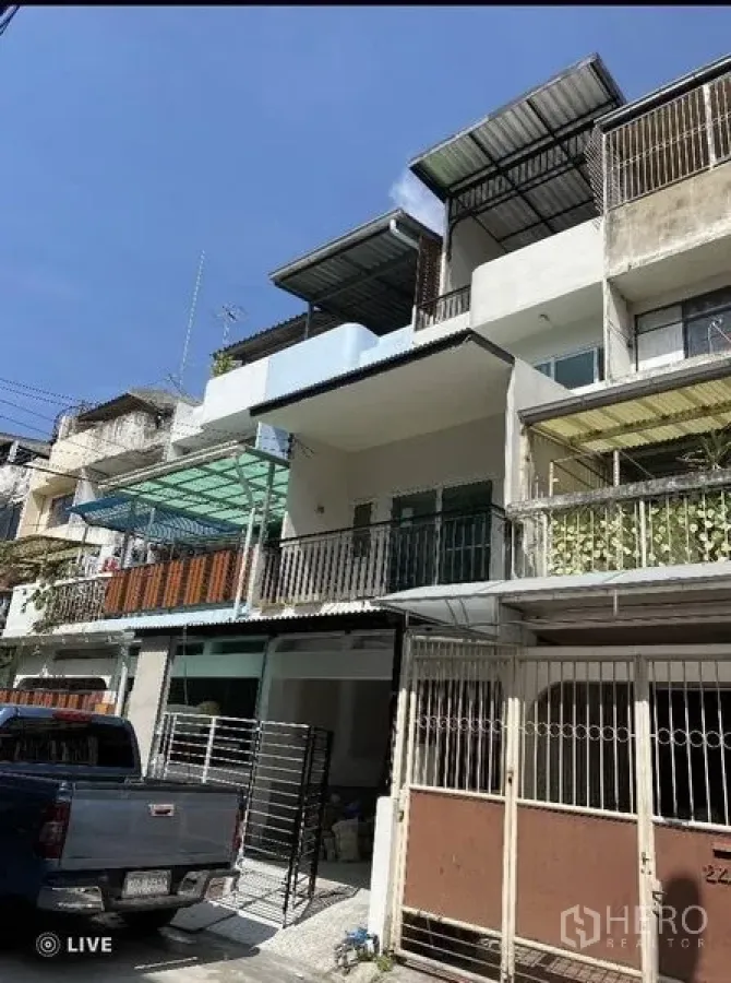 联排别墅 出售在Khlong Toei, Bangkok - 三层联排屋外立面，设阳台与金属栏杆，门前有雨棚，位于艾卡迈。