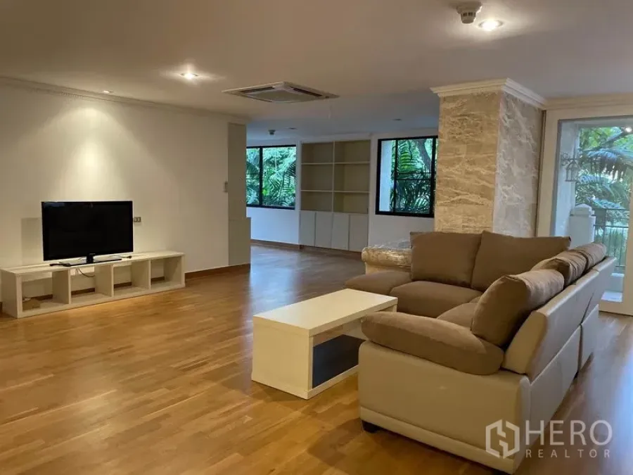 Condominium for rent in Watthana, Bangkok - Expansive living room with sectional sofa, TV unit and built-in cabinetry.