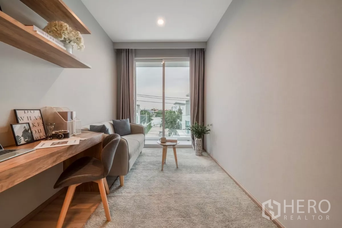 Detached House for rent in Saphan Sung, Bangkok - Study nook with floating desk, armchair and sliding glass door to a balcony.