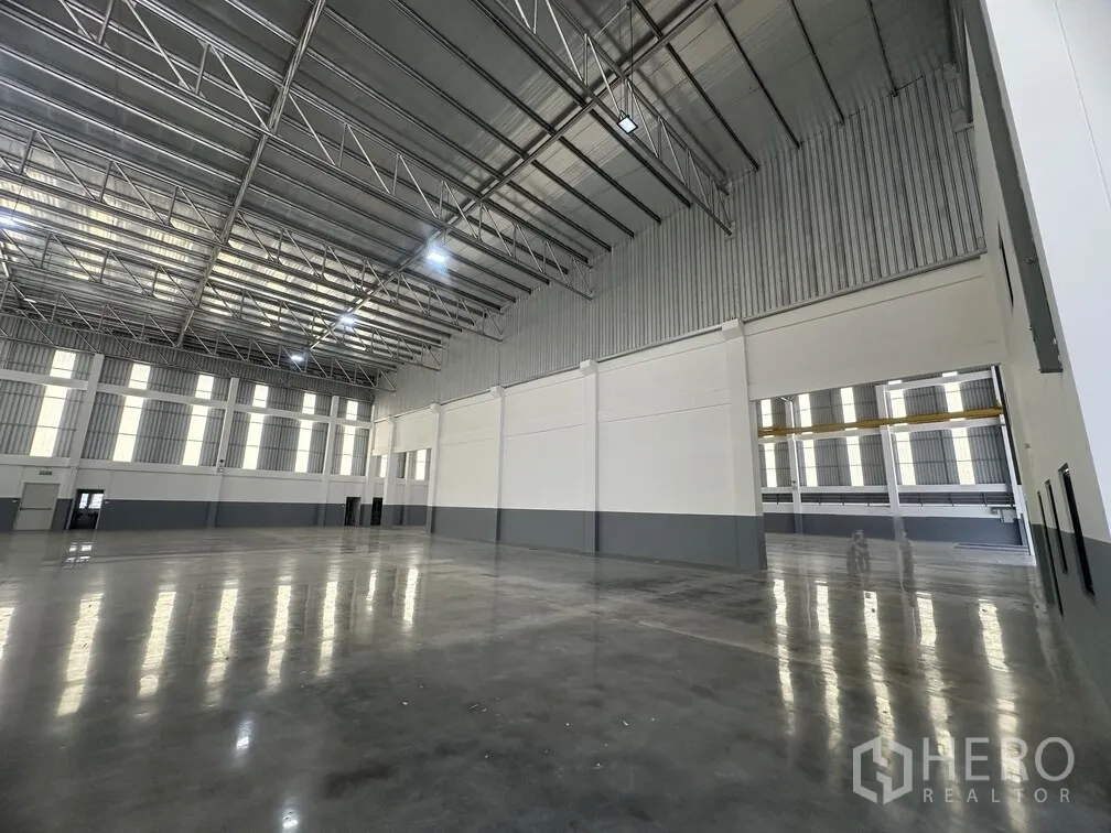 Factory for rent in Bang Phli, Samut Prakan - Corner view of connected bays with polished concrete floor and metal roof.