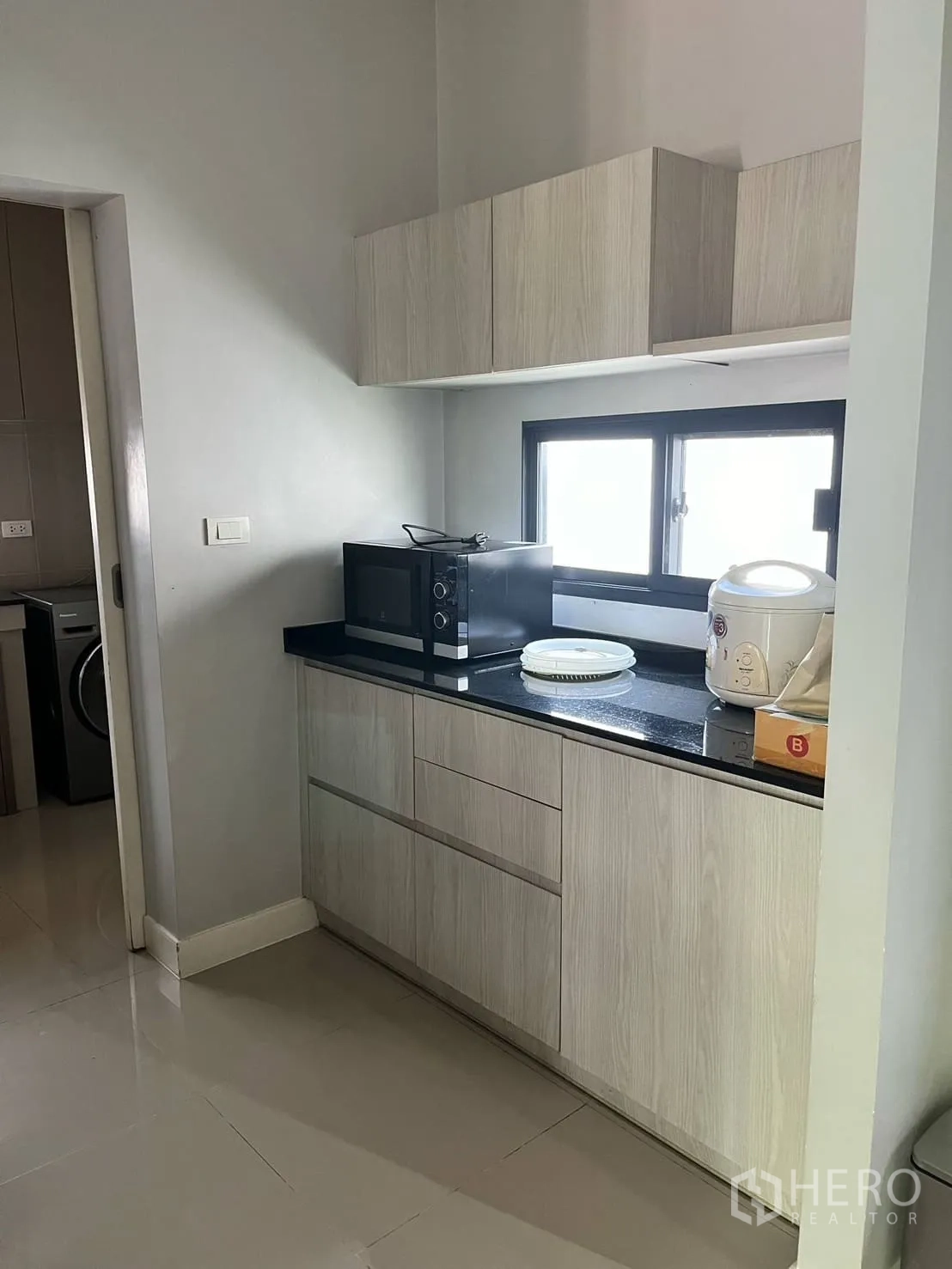 Detached House for rent or sale in Lam Luk Ka, Pathum Thani - Pantry with light wood cabinets, black countertop and appliances.