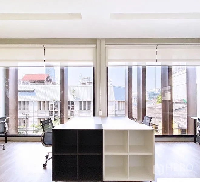 Office Space for rent in Bang Rak, Bangkok - Office with floor-to-ceiling windows, roller blinds, storage cubbies, and city views.