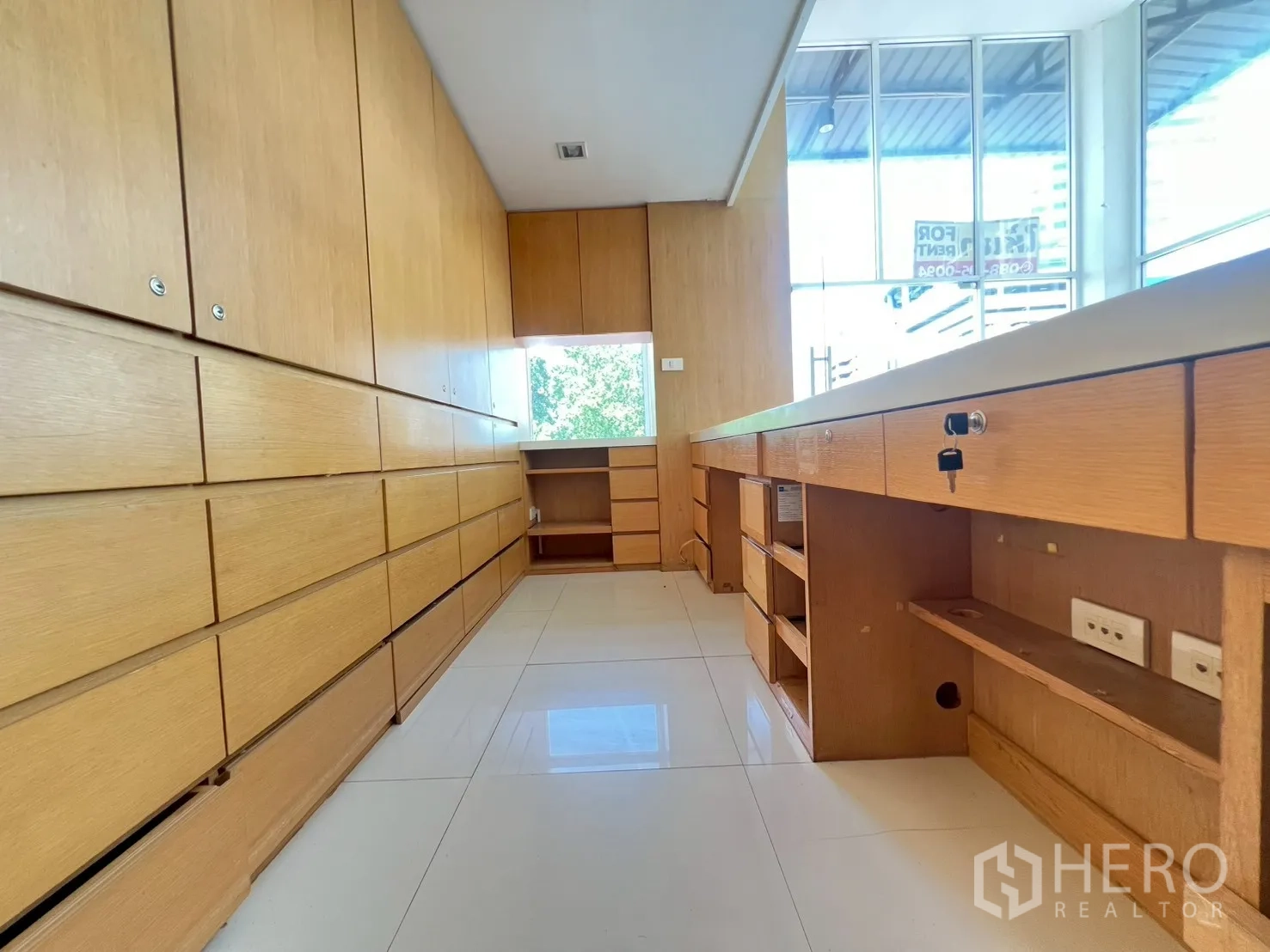 พื้นที่ขายของ for rent in Watthana, Bangkok - ทางเดินเก็บของพร้อมตู้และลิ้นชักบิวท์อินยาว มีโต๊ะทำงานติดหน้าต่าง