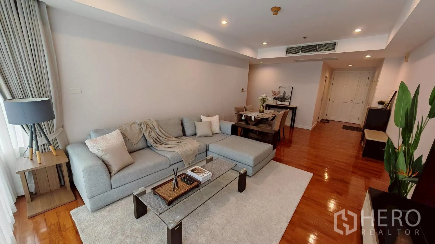 คอนโด for rent in Khlong Toei, Bangkok - มุมมองเพิ่มเติมของโซนพักผ่อนพร้อมโซฟาเข้ามุมและโต๊ะทานอาหารบนพื้นไม้.