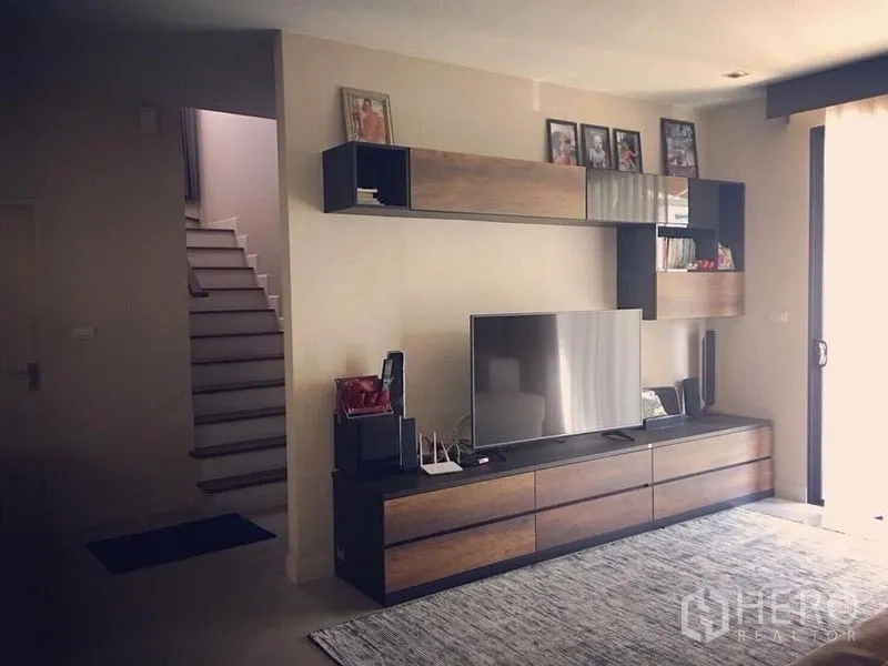 Detached House for sale - Lounge with built-in media cabinet and shelving beside the staircase.
