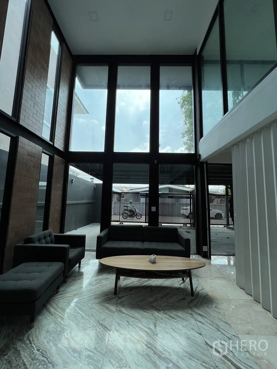 Detached House for rent or sale in Phra Khanong, Bangkok - High-ceiling lounge with panoramic windows bringing abundant natural light.