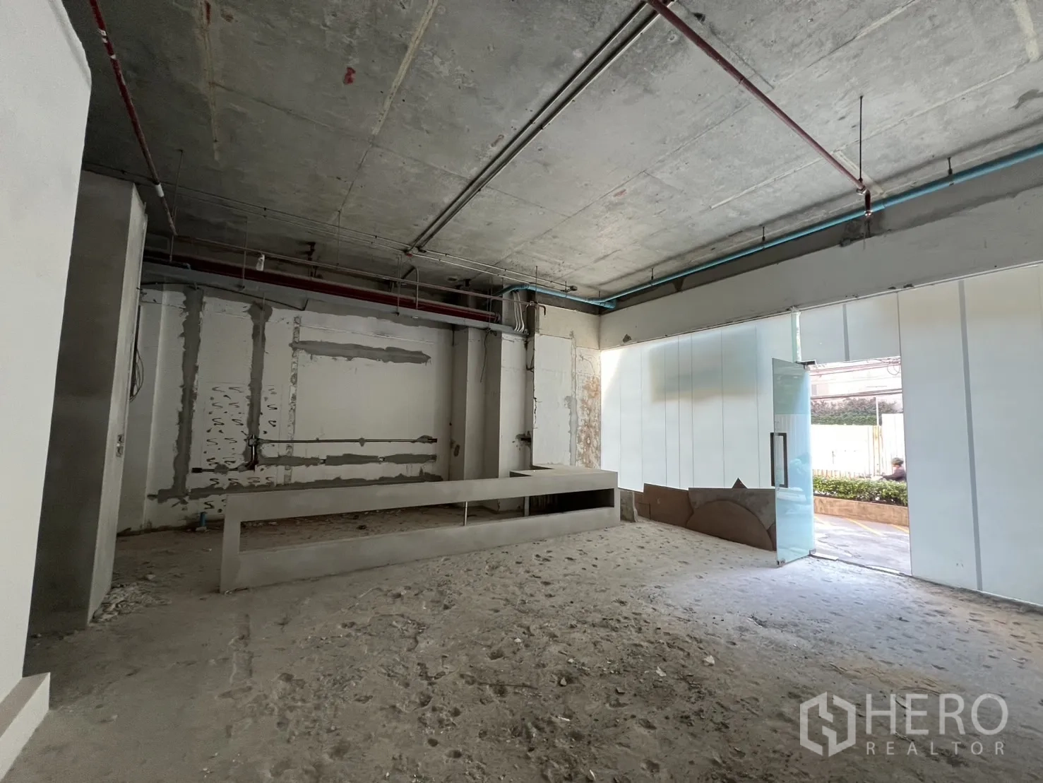 零售空间 出租在Khlong Toei, Bangkok - 开阔毛坯空间，玻璃入口与混凝土吧台基座