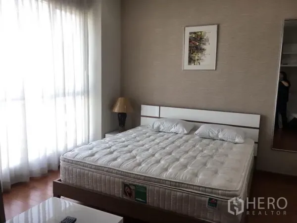 公寓 出租在Pathum Wan, Bangkok - 明亮卧室，落地窗与纱帘，白色床架和床垫。