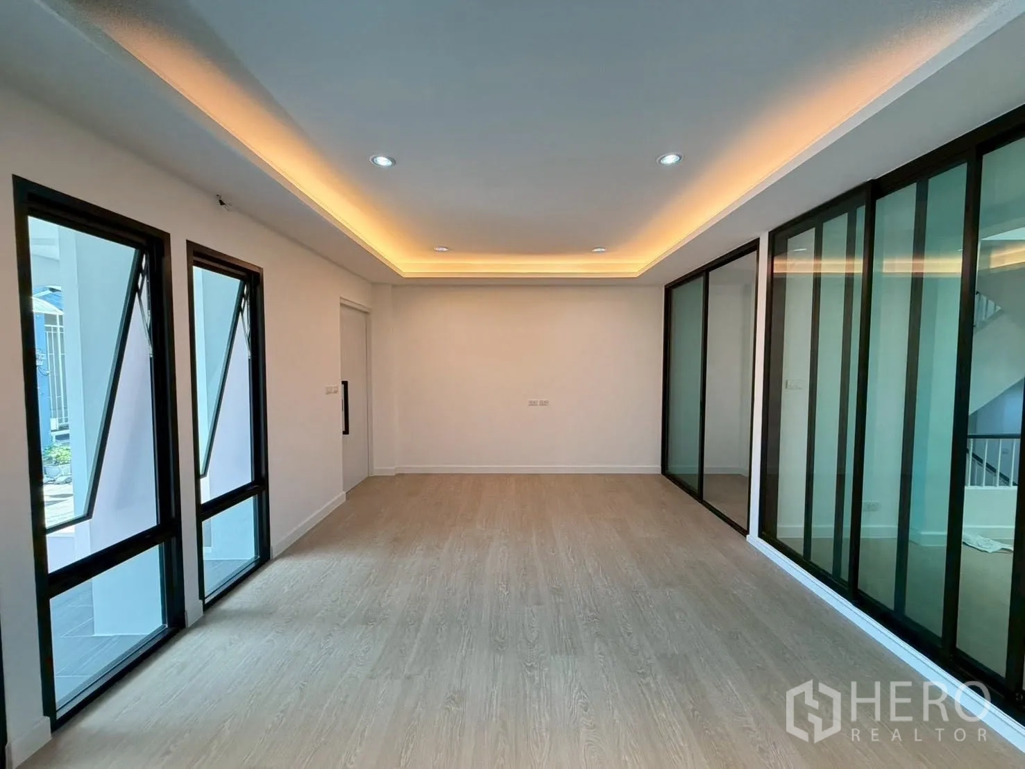 Townhouse for sale in Phra Khanong, Bangkok - Room divided by full-height sliding glass partitions and corner windows.