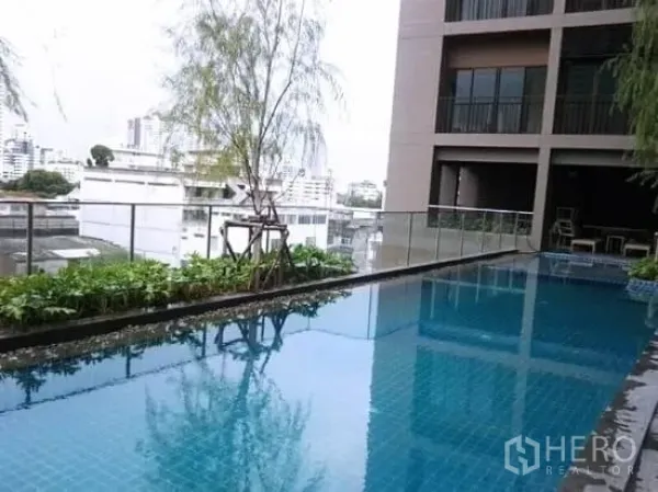 公寓 出租在Bangkok - 公寓泳池配玻璃栏杆，远眺曼谷空堤区城市天际线。