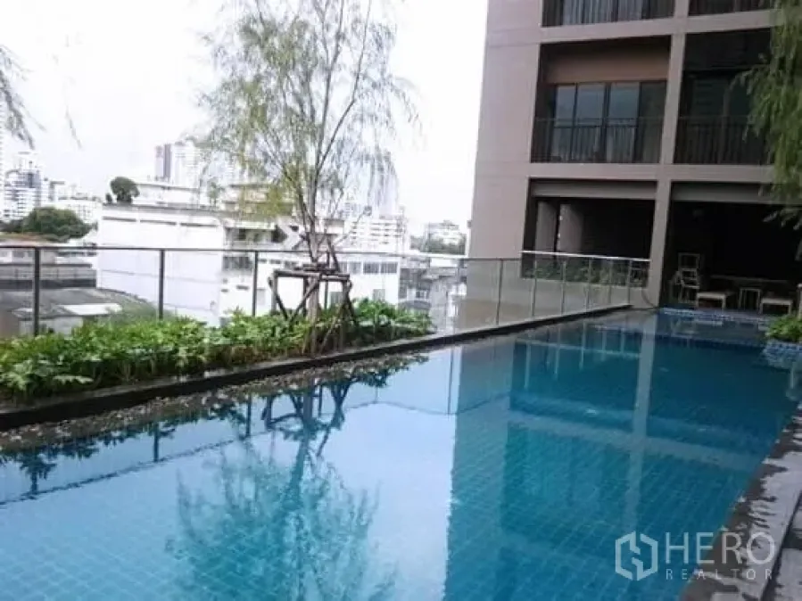 Condominium for rent in Bangkok - Condominium swimming pool with glass railing and city skyline view in Khlong Toei, Bangkok.