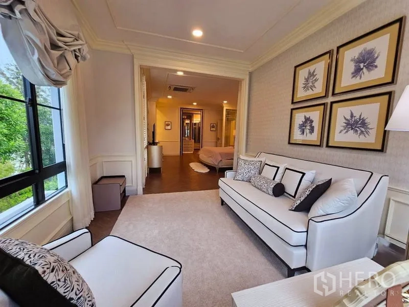 Detached House for rent or sale in Saphan Sung, Bangkok - Master suite sitting area with sofa set and large windows connected to the bedroom.