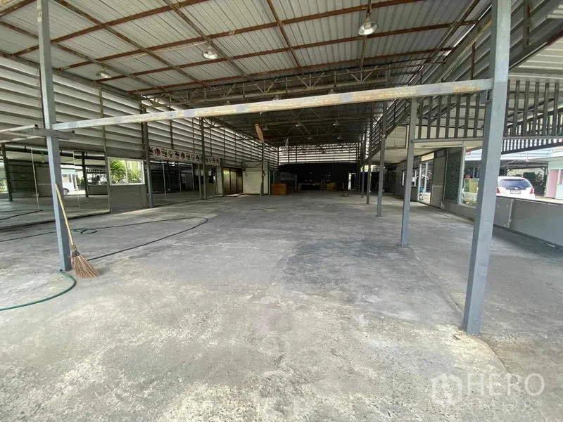 Warehouse for rent in Mueang Nonthaburi, Nonthaburi - Open-plan warehouse interior with high metal truss roof, concrete floor, and side windows.