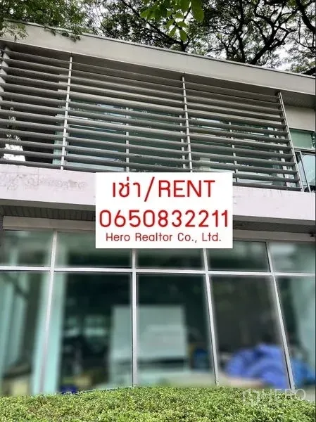 办公空间 出租在Khlong Toei, Bangkok - 现代两层办公楼外立面，水平遮阳百叶与整面落地玻璃，树荫环绕，前方有出租标识。