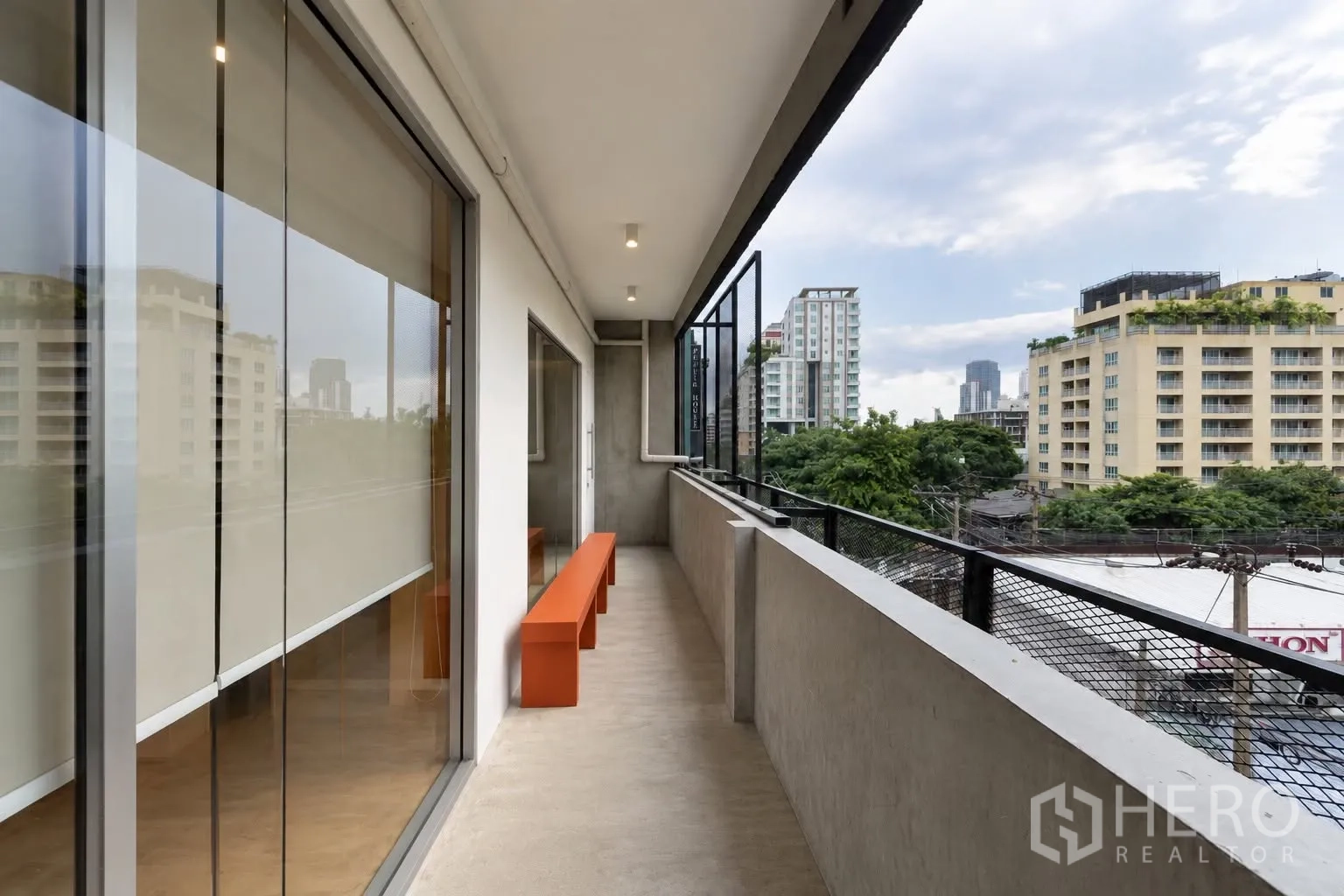 Retail Space for rent in Watthana, Bangkok - Long balcony with bench seating and urban views of surrounding buildings and trees.