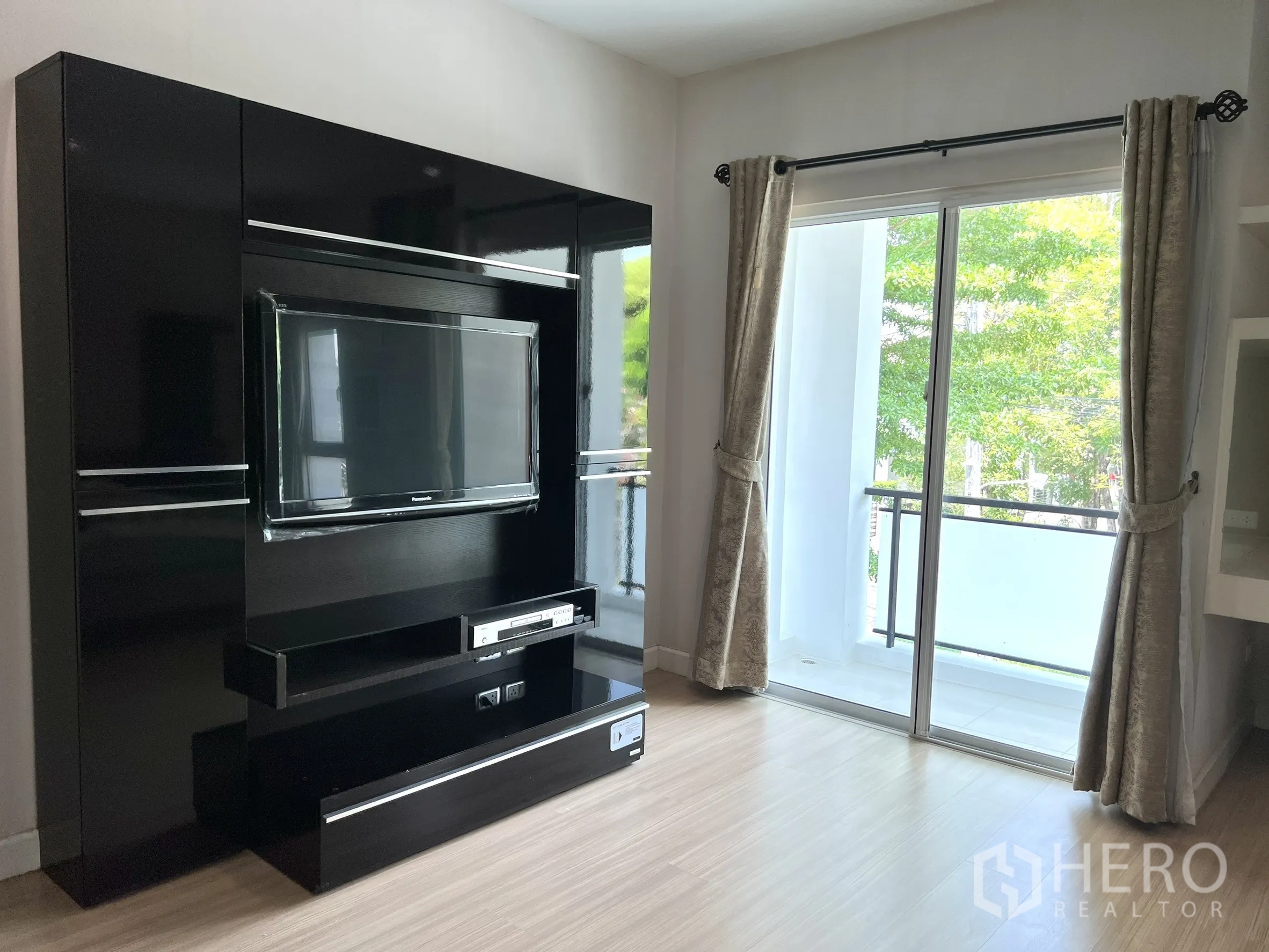独立式住宅 出租或出售在Saphan Sung, Bangkok - 带阳台的卧室，亮黑电视柜与窗帘。