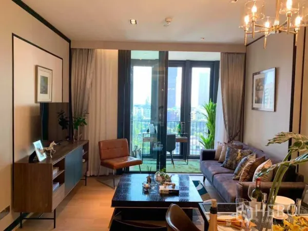 Condominium for rent in Khlong Toei, Bangkok - Living room opening to a balcony with city skyline views and abundant daylight.