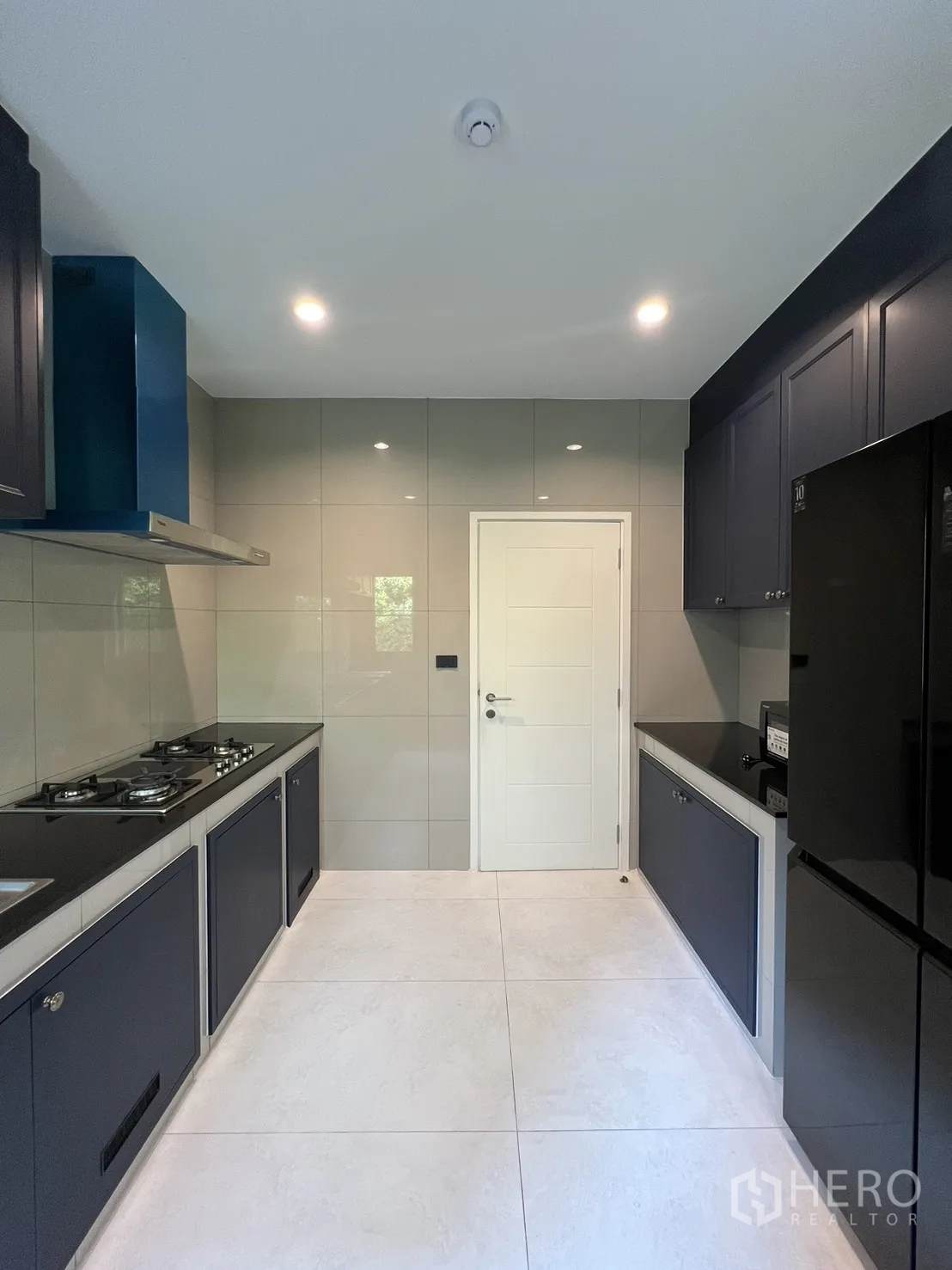Detached House for rent in Bang Phli, Samut Prakan - Separate kitchen with gas hobs, dark cabinets and a white door.