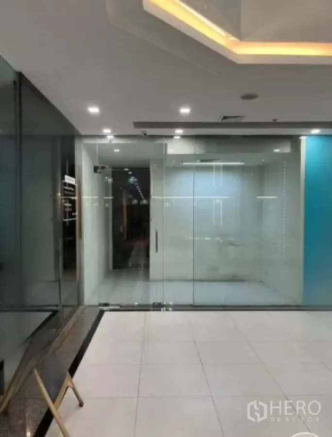 Office Space for rent - Glass-walled office entrance with recessed lighting and tiled floor.
