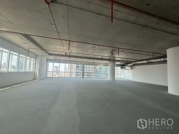 办公空间 出租在Sathon, Bangkok - 开放式办公室，混凝土地面与大片玻璃，远眺曼谷天际线，近BTS Saint Louis。