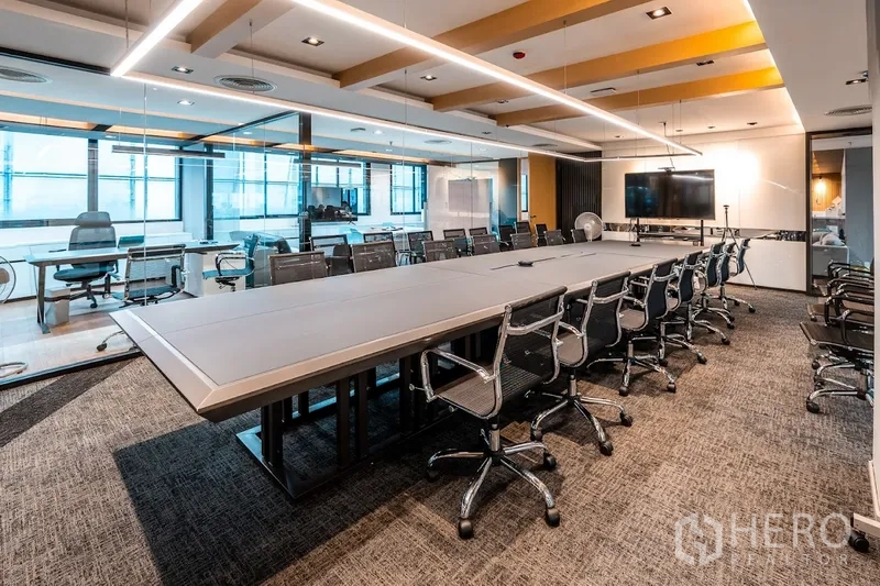 Office Space for rent in Bang Rak, Bangkok - Large conference room with a long table, swivel chairs, glass walls, and a TV display.