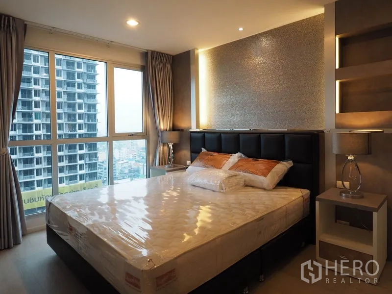 公寓 出租在Sathon, Bangkok - 主卧配软包床头与床头柜，窗外全景城市景观。
