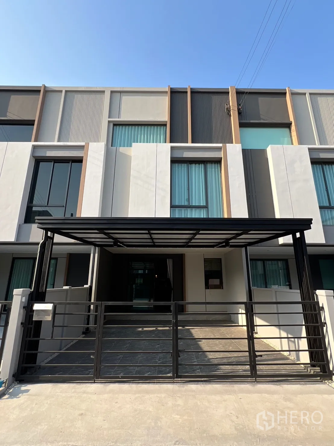 ทาวน์เฮาส์ for rent in Bang Phli, Samut Prakan - ด้านหน้าทาวน์เฮ้าส์สไตล์โมเดิร์น พร้อมรั้วและที่จอดรถมีหลังคา