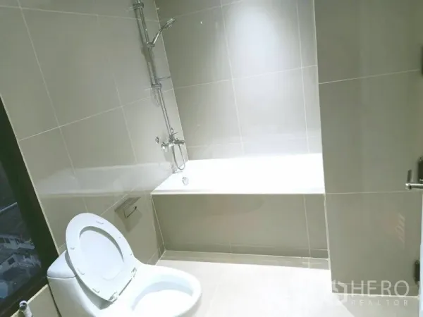 คอนโด for ในWatthana, Bangkok - ห้องน้ำสว่างพร้อมอ่างอาบน้ำ ฝักบัว และกระเบื้องสีเทาอ่อน