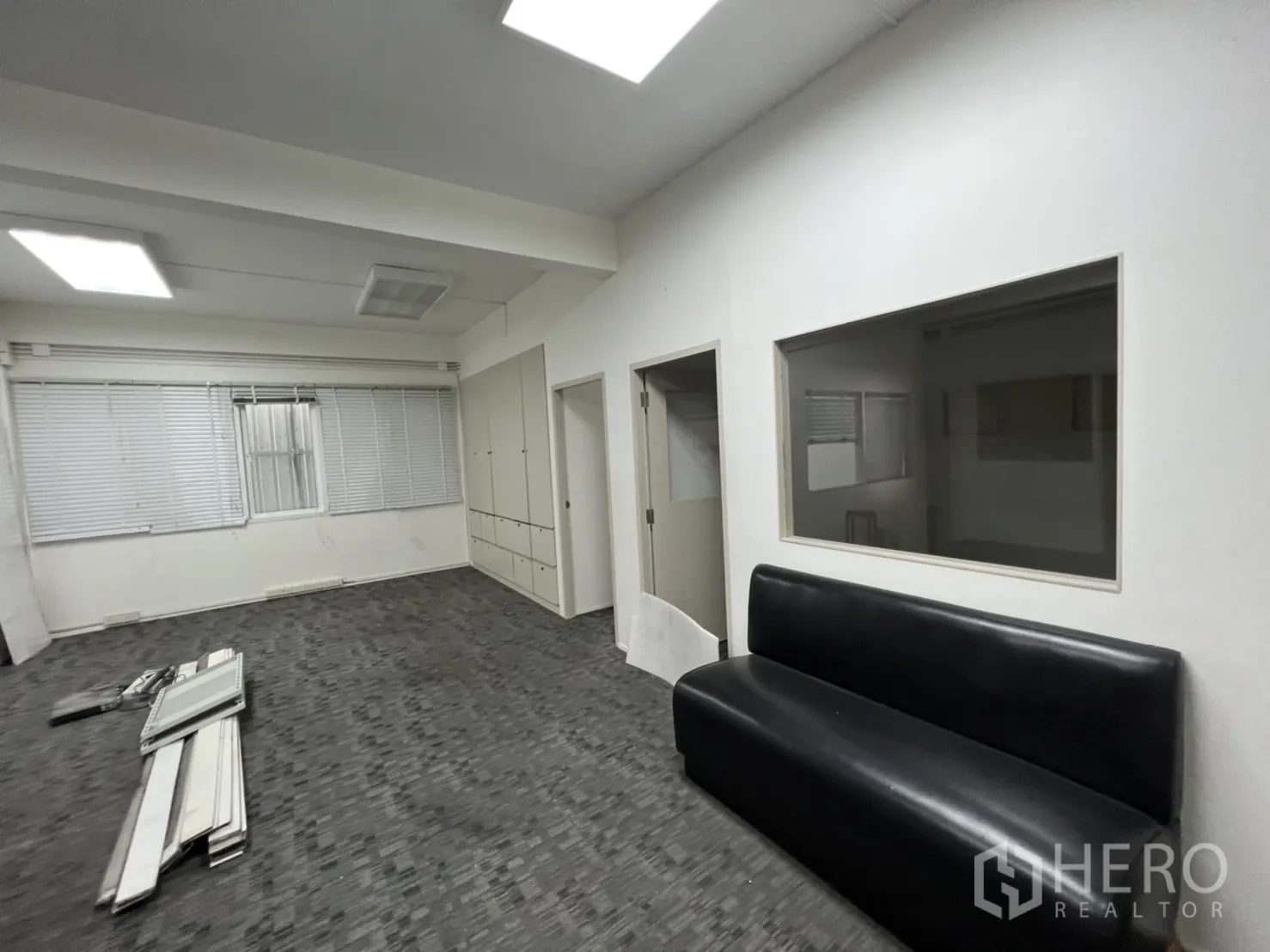 Shophouse for rent or sale in Watthana, Bangkok - Workroom with large windows, a sofa and materials on the floor.
