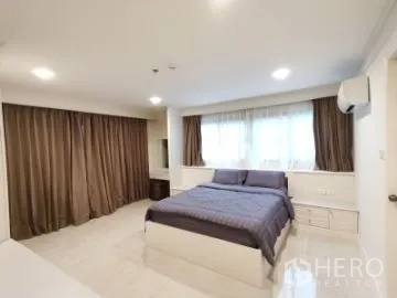 Apartment for rent in Watthana, Bangkok - Bright bedroom with large window, brown curtains and double bed.