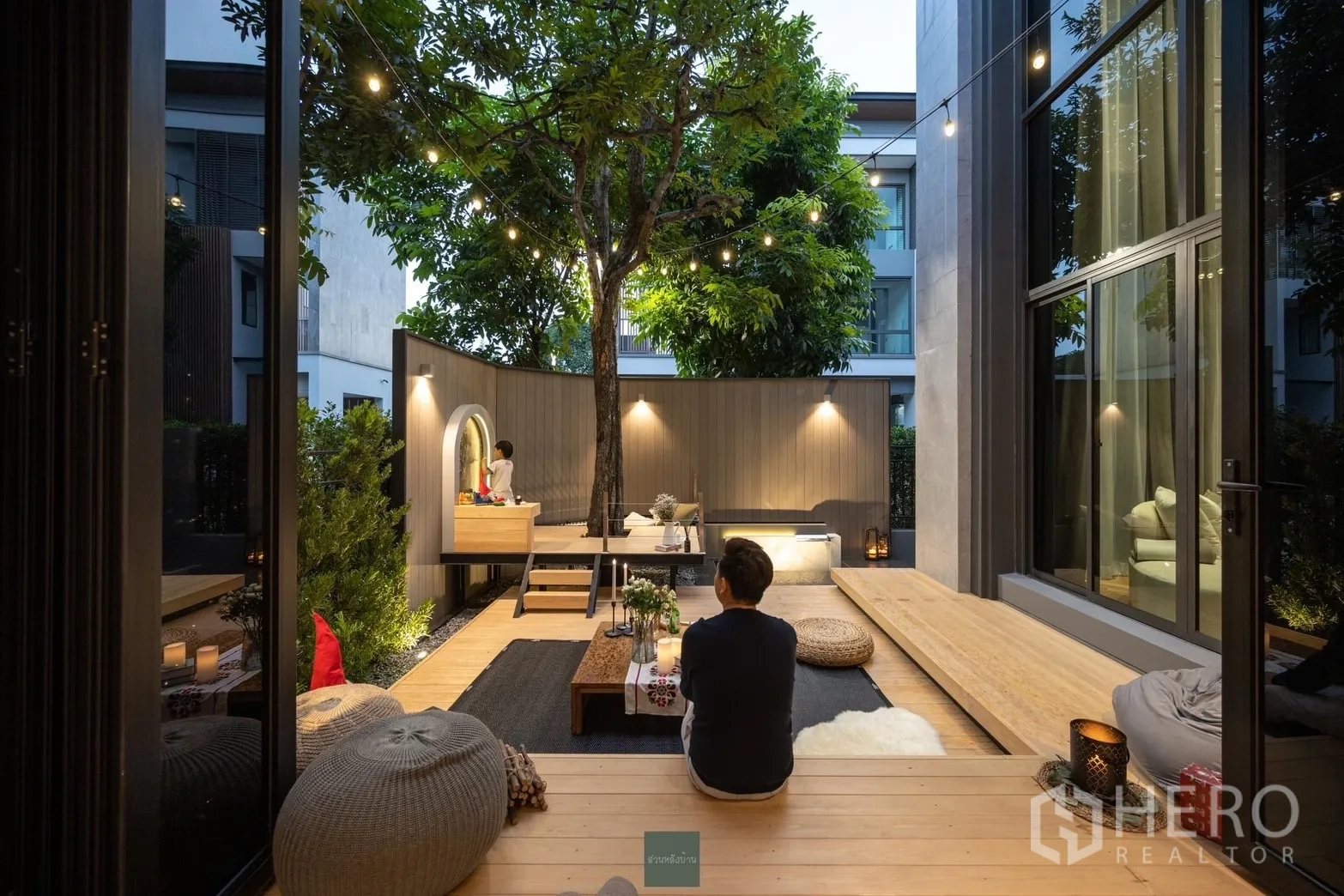 Detached House for rent or sale in Phra Khanong, Bangkok - Evening courtyard deck with string lights, built-in seating and a reflecting pond.