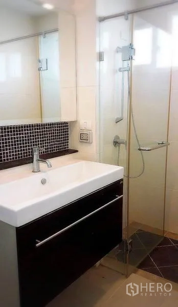 Detached House for rent or sale in Bang Yai, Nonthaburi - Modern bathroom with vanity sink, glass shower enclosure and wall mirror.
