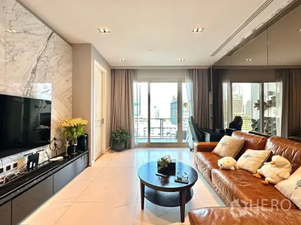 公寓 出租在Pathum Wan, Bangkok - 明亮客厅， 大理石电视墙、皮沙发、电视柜与阳台城市景观。