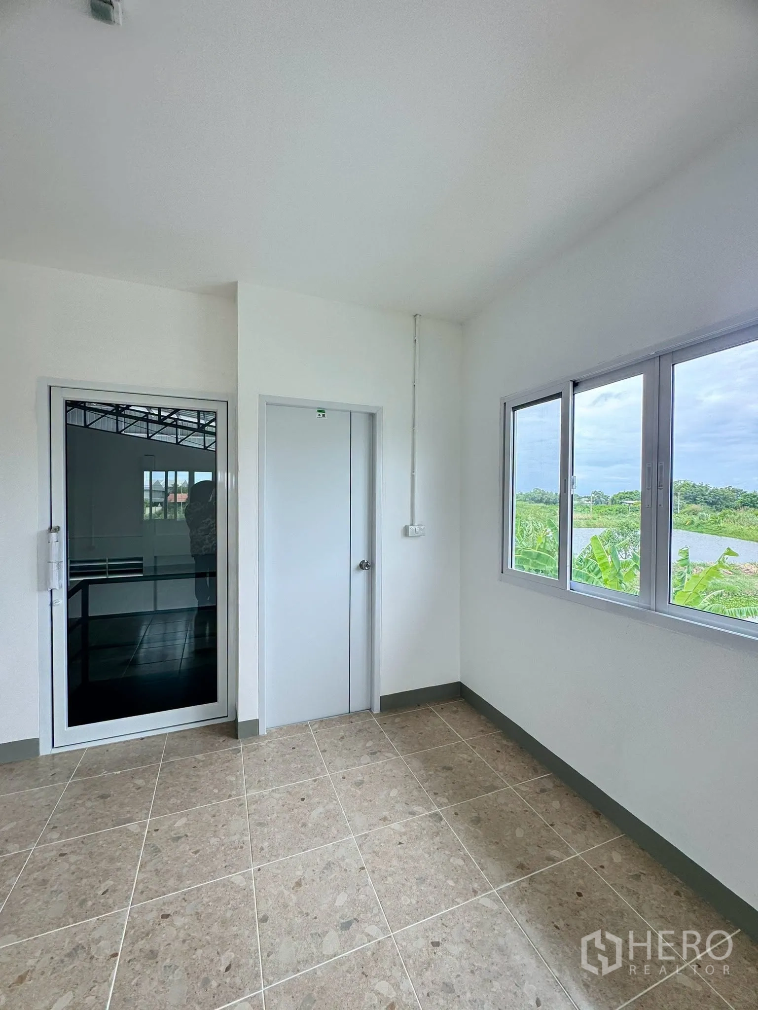 Warehouse for rent in Bang Bo, Samut Prakan - Upstairs office room with tiled floor, sliding windows, and an outdoor view.
