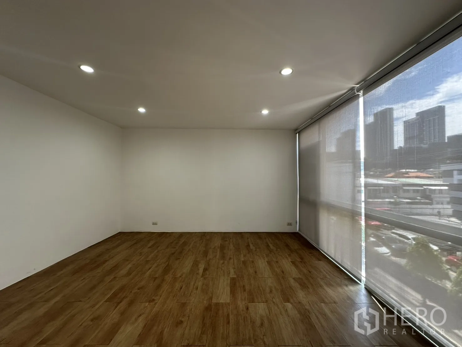 โฮมออฟฟิศ for rent in Phra Khanong, Bangkok - พื้นที่ทำงานขนาดใหญ่พื้นลายไม้และหน้าต่างสูงเต็มผนังพร้อมม่าน.